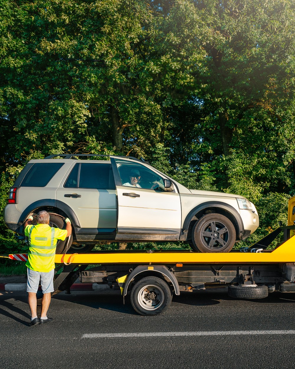 tow-truck-broken-car-road-against-trees-city